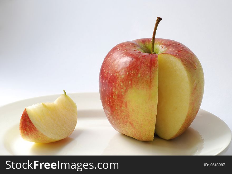 Juicy apple and its clove on a plate