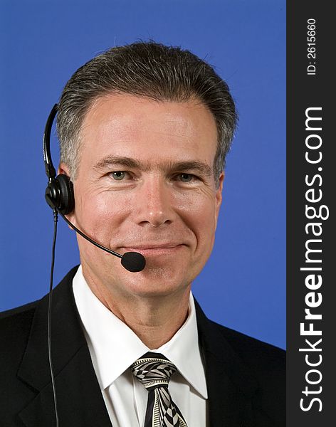 A man with a headset on as if manning a helpdesk or facilitating communication in some way. A man with a headset on as if manning a helpdesk or facilitating communication in some way.