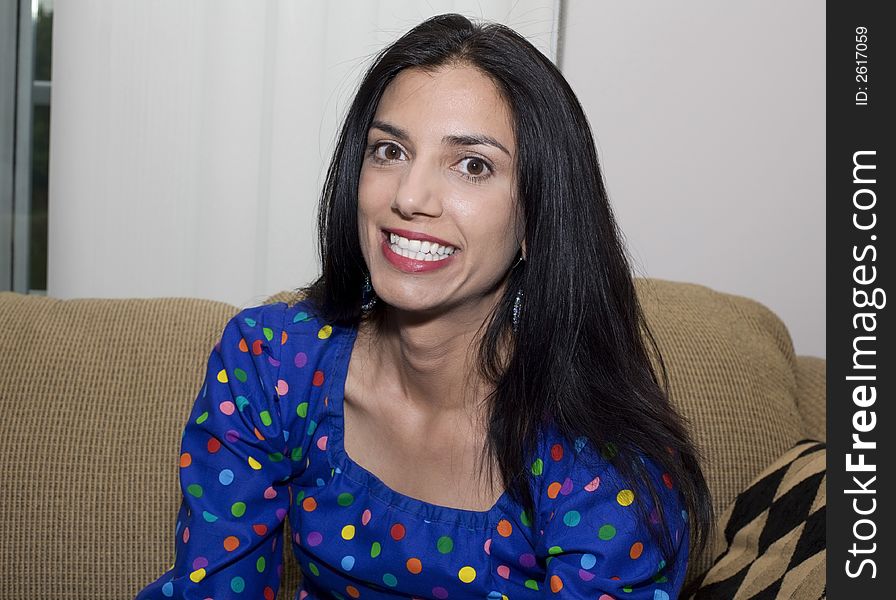 A beautiful woman smiling and sitting on the sofa