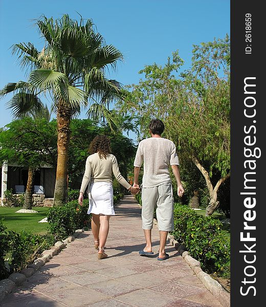 Man and woman walking on the tropical gagden