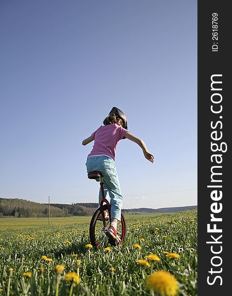 Young girl on monocycle in field