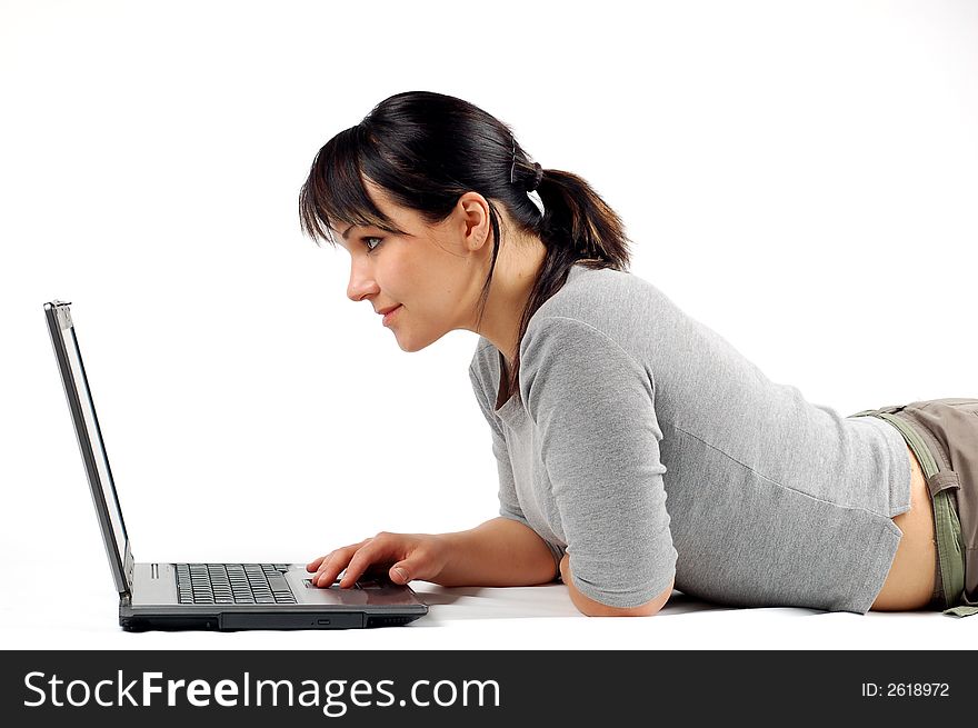 Attractive woman lying on white with laptop. Attractive woman lying on white with laptop