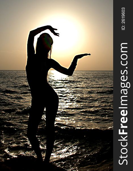 Silhouette of the girl at dawn near the sea. Silhouette of the girl at dawn near the sea