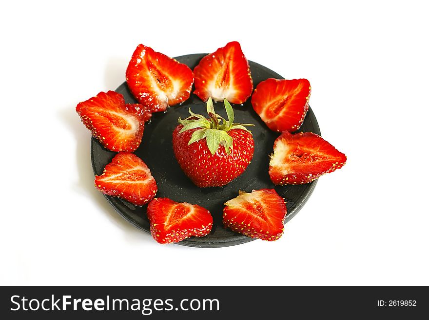 Fresh red strawberries on black saucer