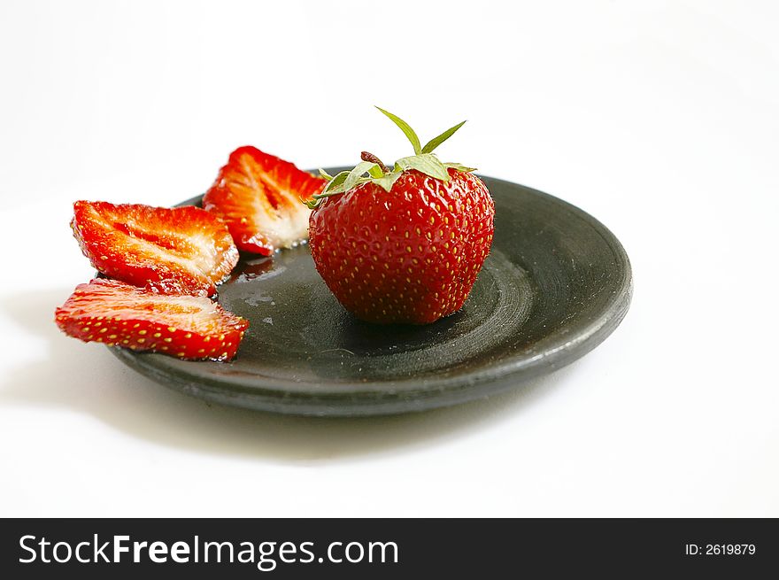 Red fresh strawberries on black saucer