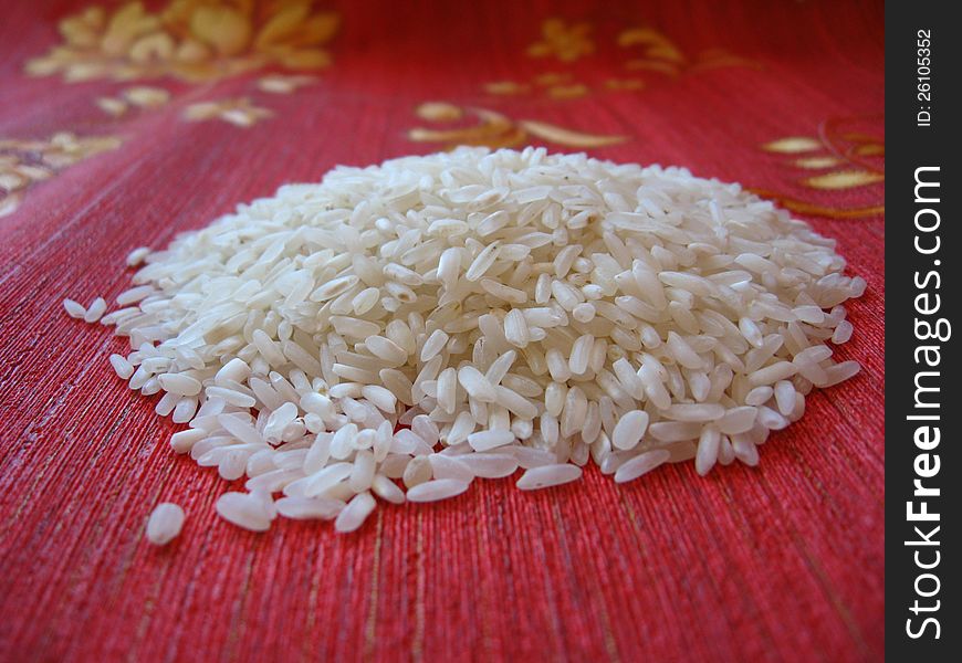 Handful of rice scattered on a red background. Handful of rice scattered on a red background
