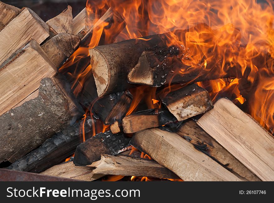 Burning logs of firewood and tongues of flame. Burning logs of firewood and tongues of flame