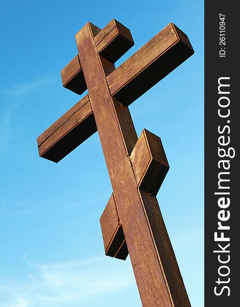 The wooden cross on a blue sky background