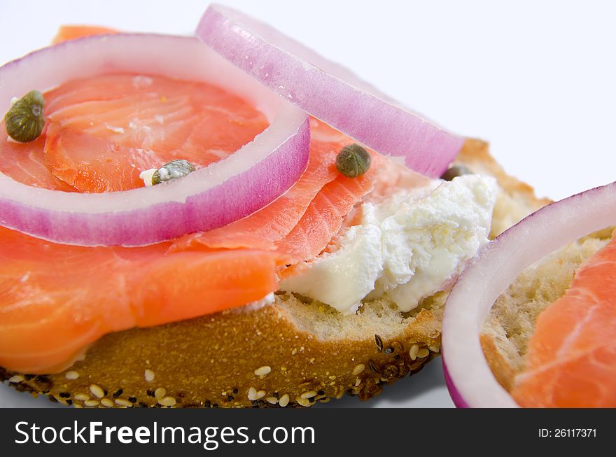 Lox and cheese with capers and onions on a toasted bagel that is covered with seeds. Lox and cheese with capers and onions on a toasted bagel that is covered with seeds