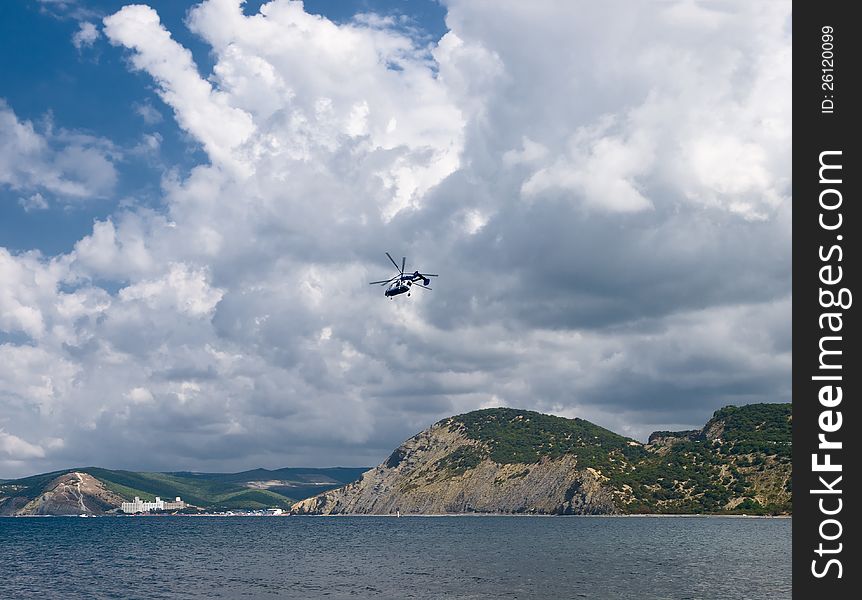 Summer landscape with sea, rocks, cloudscape and helicopter. Summer landscape with sea, rocks, cloudscape and helicopter