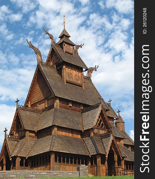 Close-up of a wooden Norwegian stave Christian church against a background of blue sky and clouds. Close-up of a wooden Norwegian stave Christian church against a background of blue sky and clouds.