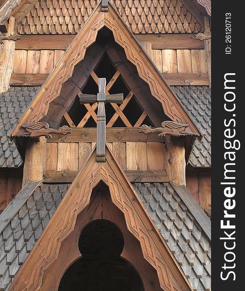 Close-up details of part of a wooden Norwegian stave church. Showing peaked gables, cross, shingles, and carved dragons. Close-up details of part of a wooden Norwegian stave church. Showing peaked gables, cross, shingles, and carved dragons.