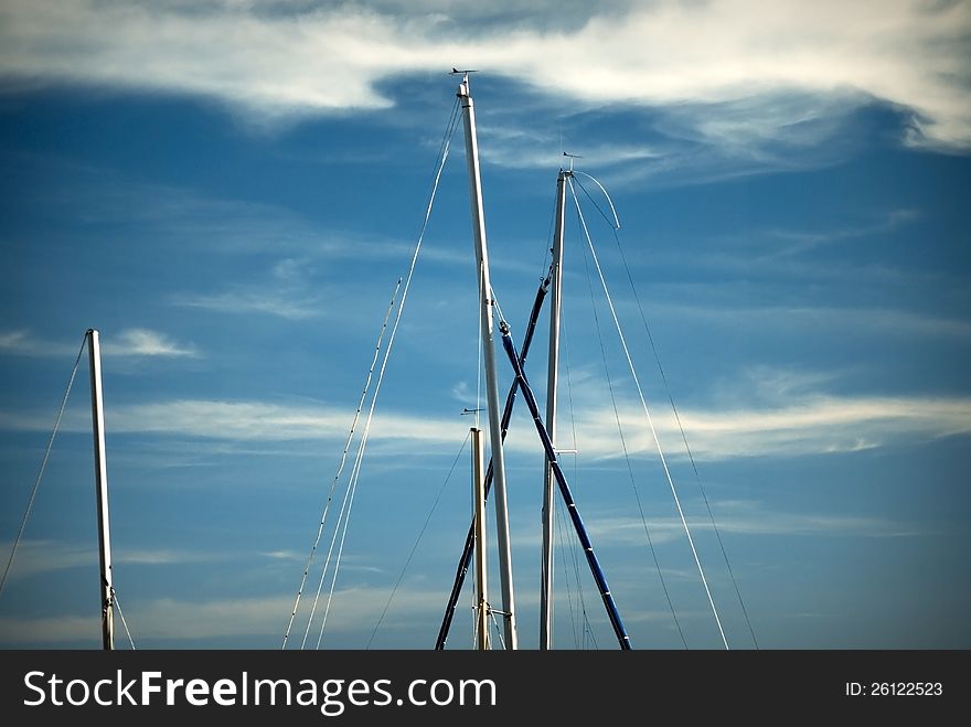 Sail masts against magic blue summer sky