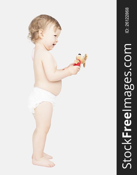 Portrait of cute little caucasian girl in pants standing and holding toy. Portrait of cute little caucasian girl in pants standing and holding toy