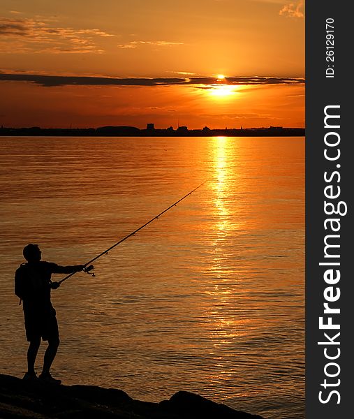 A fisherman silhouette at sunset. A fisherman silhouette at sunset