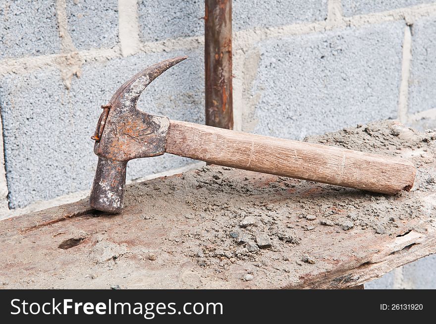 Old hammer on construction background