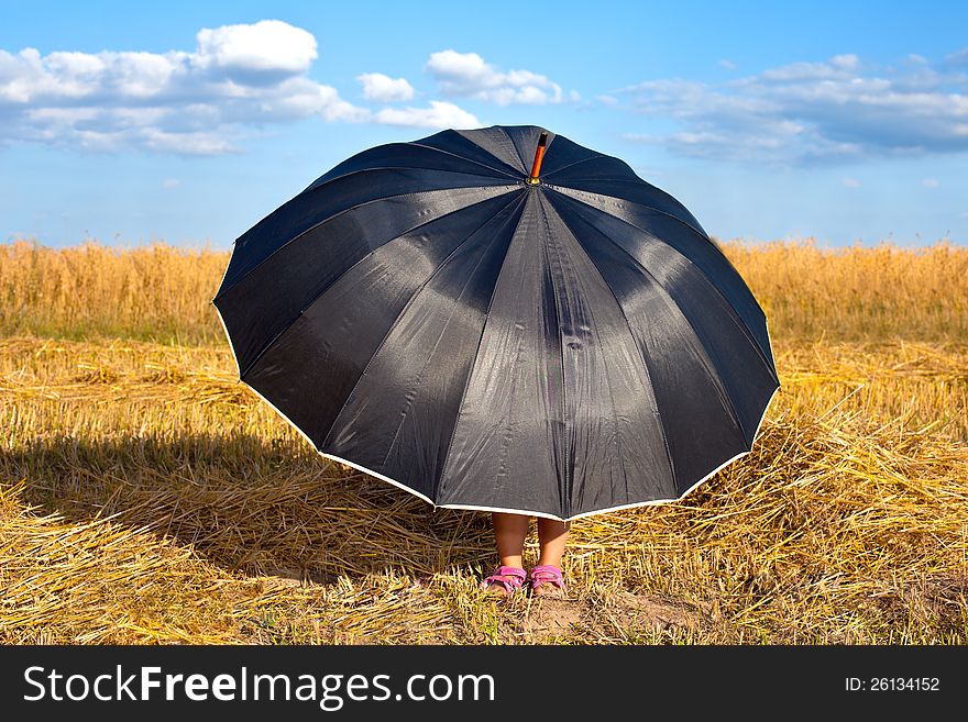 Little girl hiding under big black umbrella in fair weather. Little girl hiding under big black umbrella in fair weather