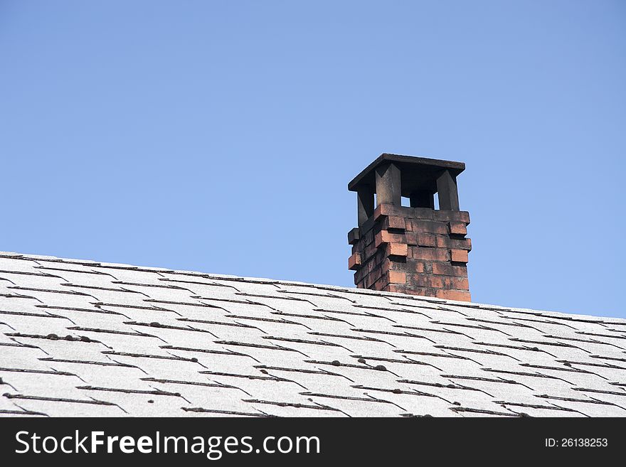 Chimney on tile roof against blue sky. Chimney on tile roof against blue sky