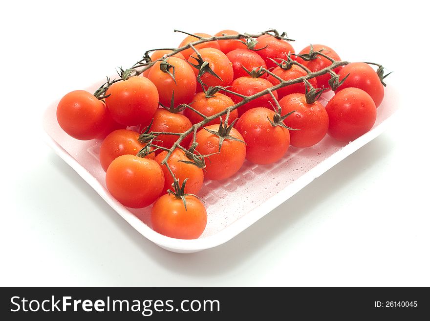 Cherry tomatoes on vine with water drops.