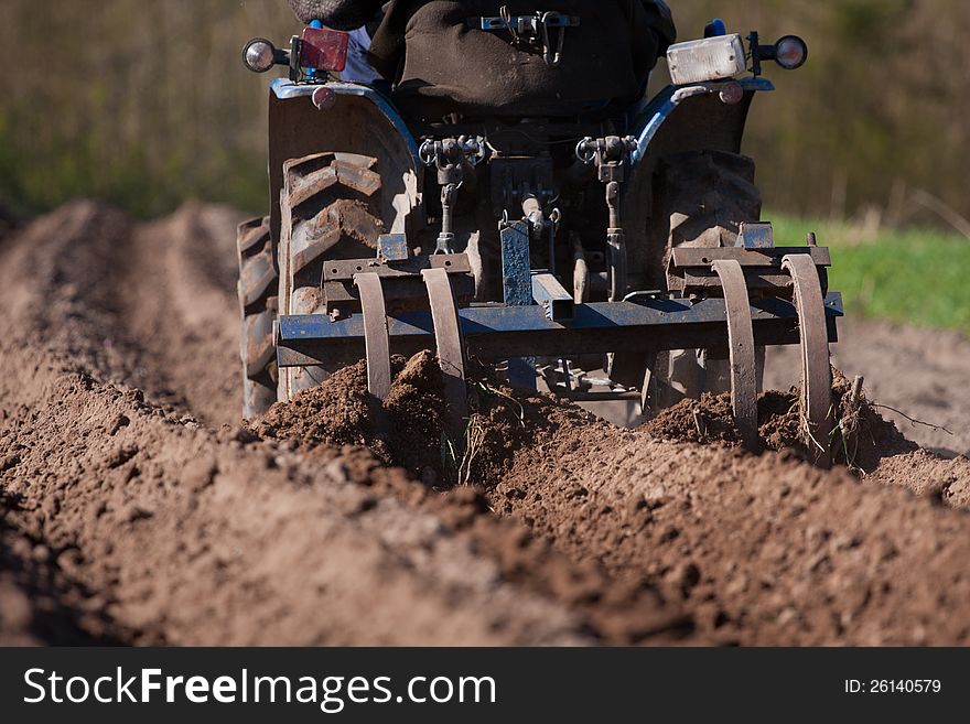 Closeup of a tractor plowing the field for sowing. Closeup of a tractor plowing the field for sowing.