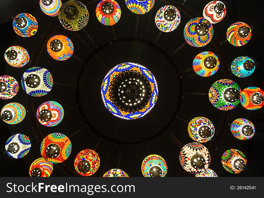 Colorful hanging round glass lamp hang from black background ceiling