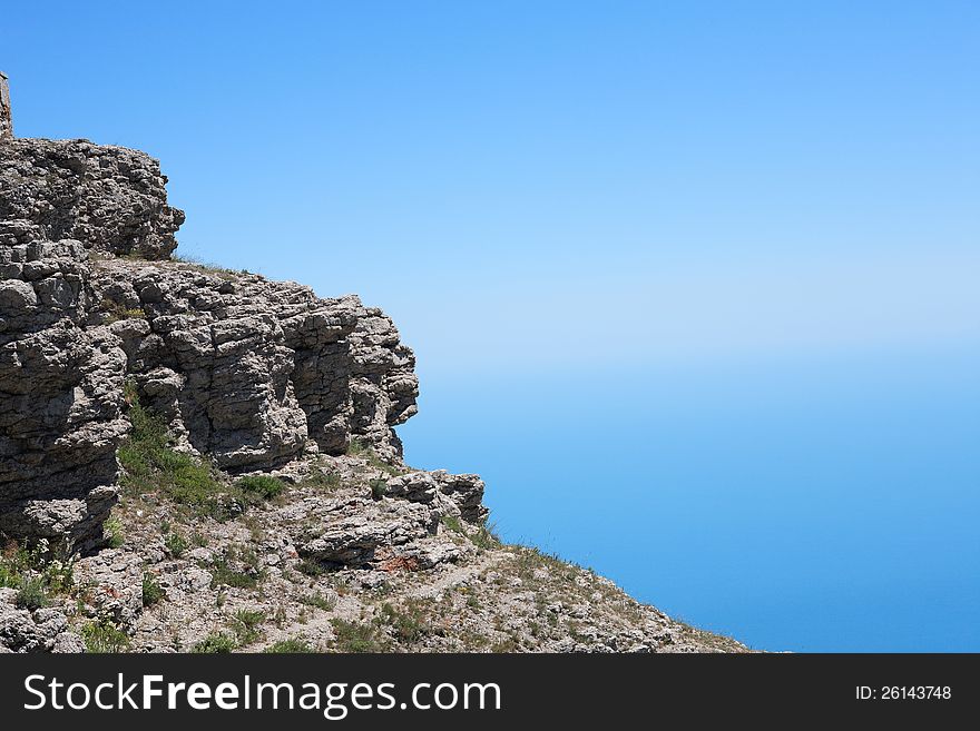 Closeup of stone slope on blue sea and sky. Good background. Closeup of stone slope on blue sea and sky. Good background