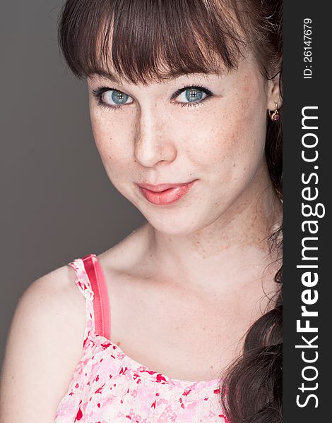 Close-up portrait of a beautiful smiling girl with freckles. Close-up portrait of a beautiful smiling girl with freckles