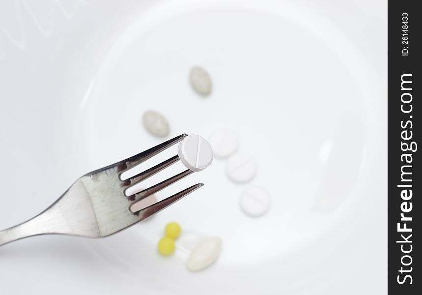 Image white pills on the fork. Image white pills on the fork