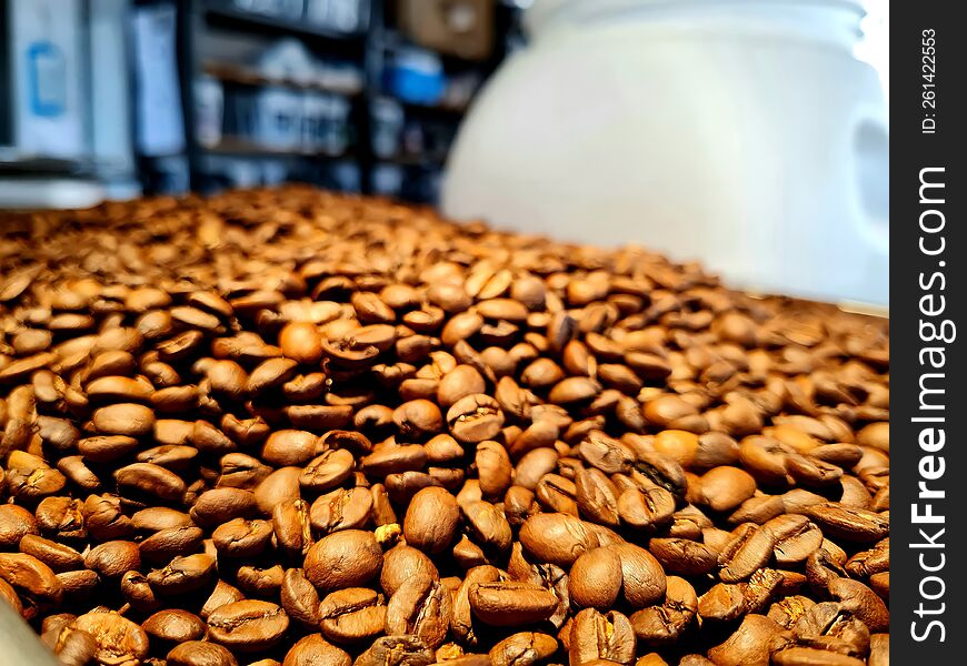 Coffee beans lie in large quantities on the shelf before roasting