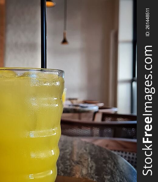 Yellow Lemonade With A Black Straw Stands On A Wooden Table