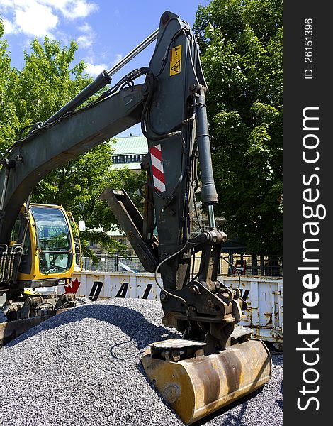 An excavator with bucket in a pile of gravel. An excavator with bucket in a pile of gravel