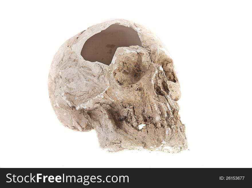 Close up of a broken skull sculpture on white background, made of plaster