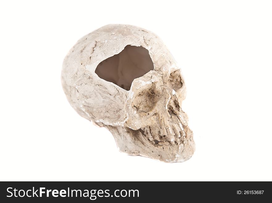 Close up of a broken skull sculpture on white background, made of plaster