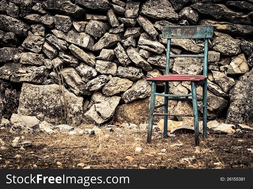 Vintage chair infront of a rock wall. Vintage chair infront of a rock wall.