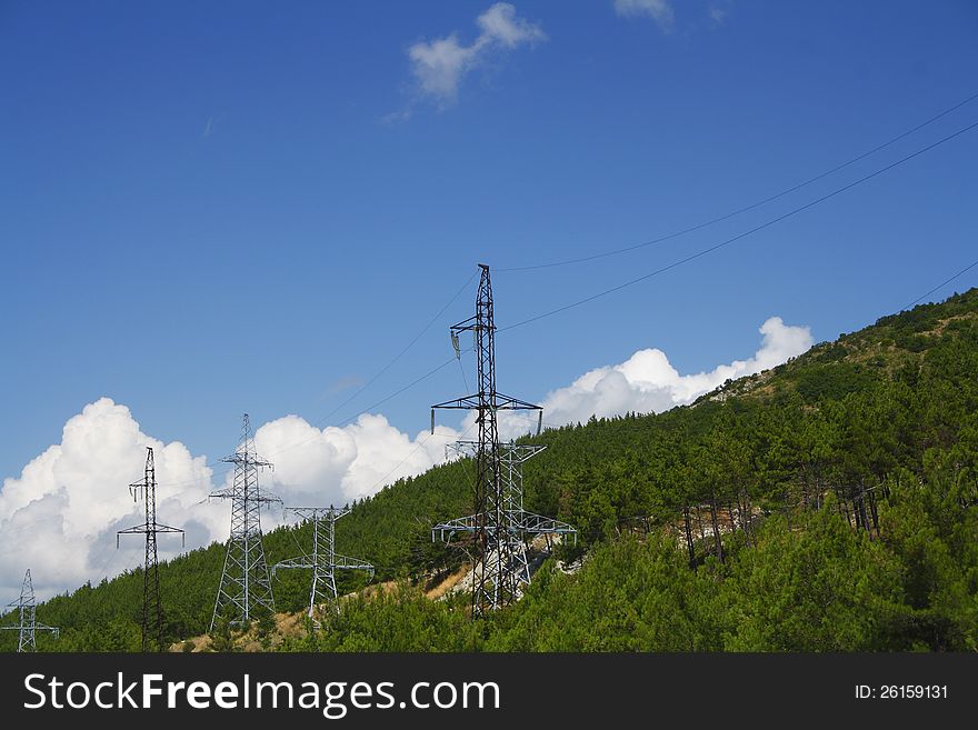 High-voltage power line across forest on moutine