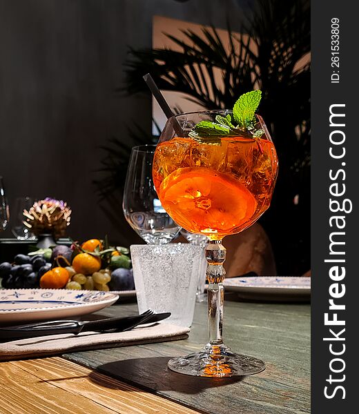 Aperol Cocktail On A Table With A Black Straw