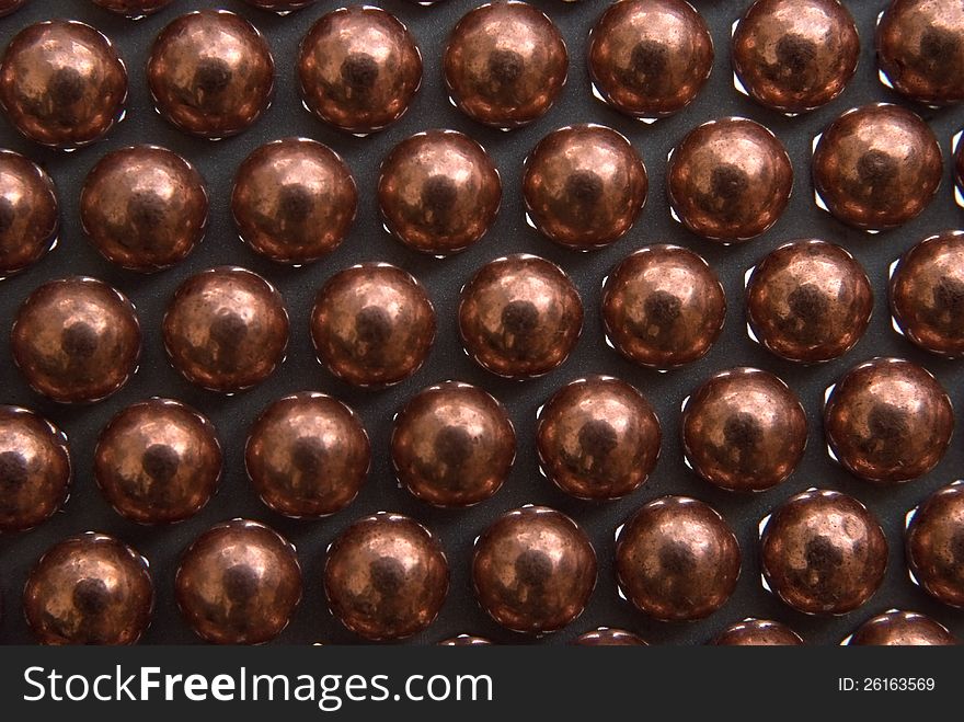 Little golden Metallic Magnetic balls lying in rows