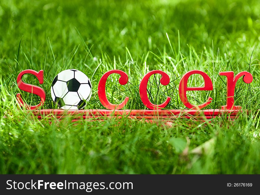 Inscription soccer on the green grass at football field