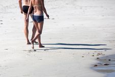 Couple Walks Along The Beach Royalty Free Stock Photos