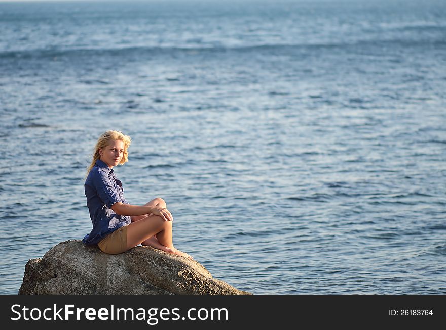 Girl Is Sitting On A Rock Near The Sea