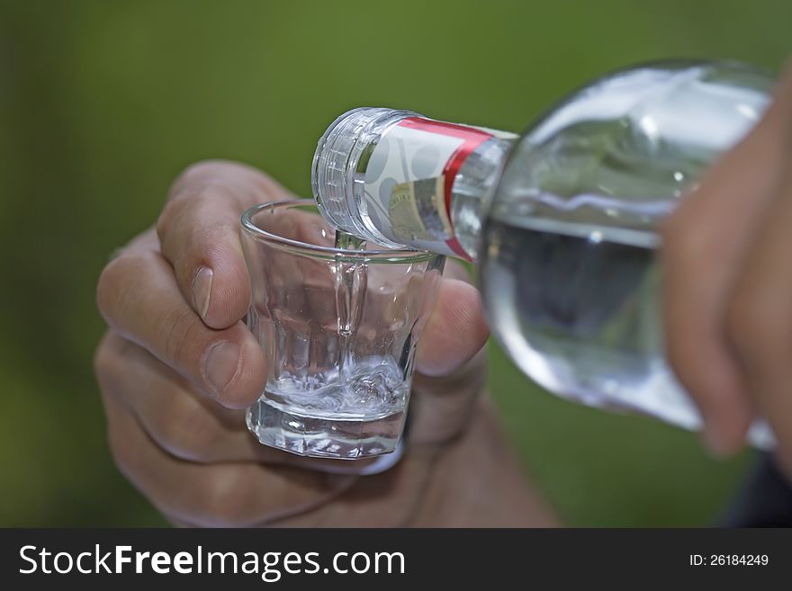 Color photo of a glass cup with liquor. Green background. Color photo of a glass cup with liquor. Green background.