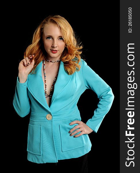 Young woman wearing a turquoise jacket on a dark background