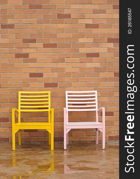 Bricyellow and pink chairs on ancient red brick