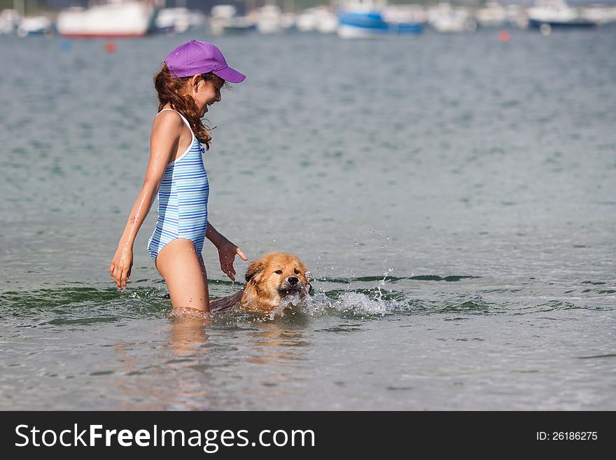 Cute girl and her Elo (German dog breed) puppy playing in the water and the puppy learns to swim. Cute girl and her Elo (German dog breed) puppy playing in the water and the puppy learns to swim