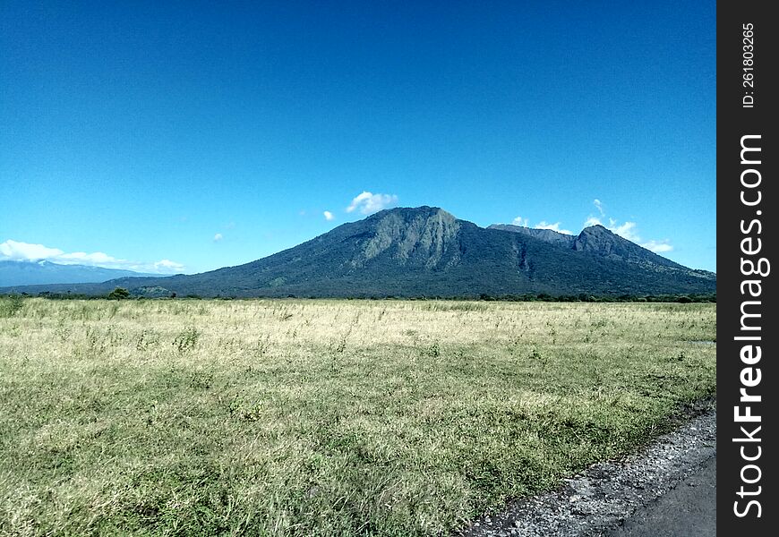 the hill looks beautiful from the roadside of the savanna with clear skies in Baluran National Park. the hill looks beautiful from the roadside of the savanna with clear skies in Baluran National Park