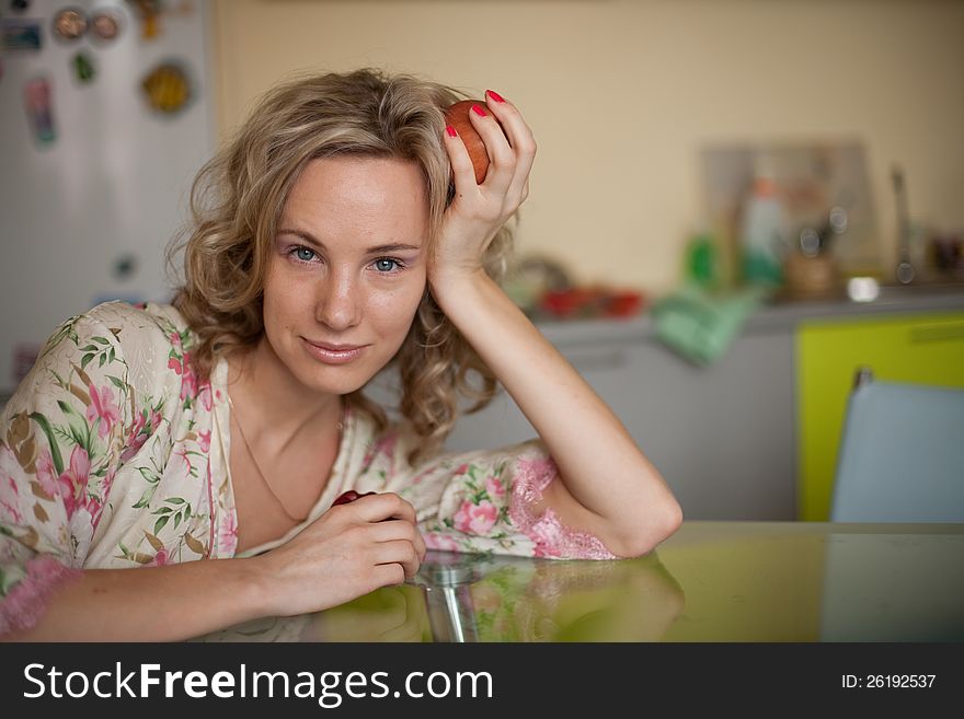 Girl with apple sitting at the table