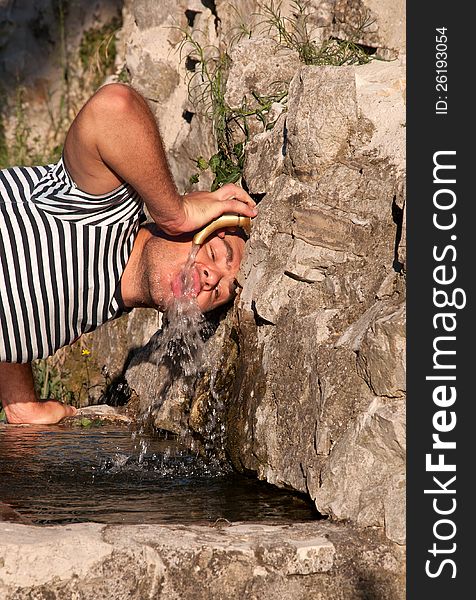 Young man drinking water from the tap