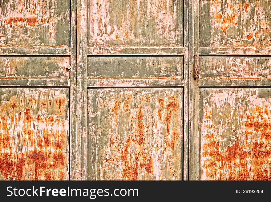 Old rusty door with hinge and keyhole