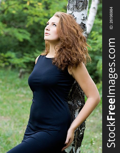 Portrait of attractive dark-haired young woman near birch tree at summer green park. Portrait of attractive dark-haired young woman near birch tree at summer green park.