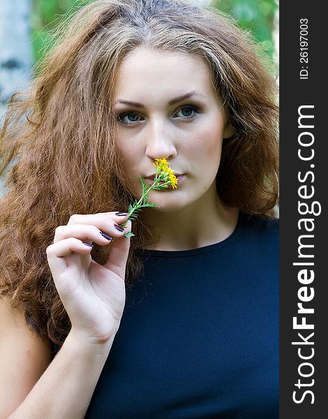 Portrait of a beautiful girl with a yellow flower. Portrait of a beautiful girl with a yellow flower